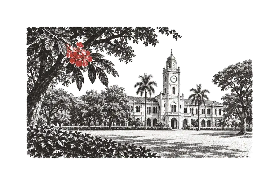 Um prédio universitário com torre de relógio, visto do gramado sob árvores; um ramo de flores vermelhas em primeiro plano.